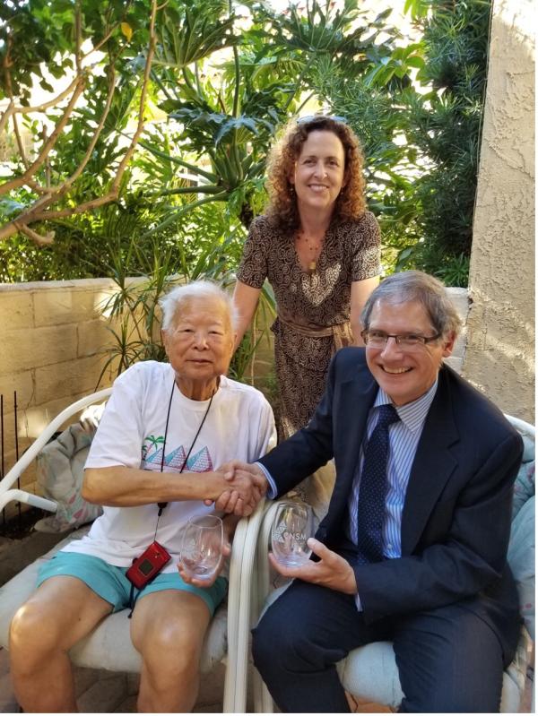 Three people pose together at an event