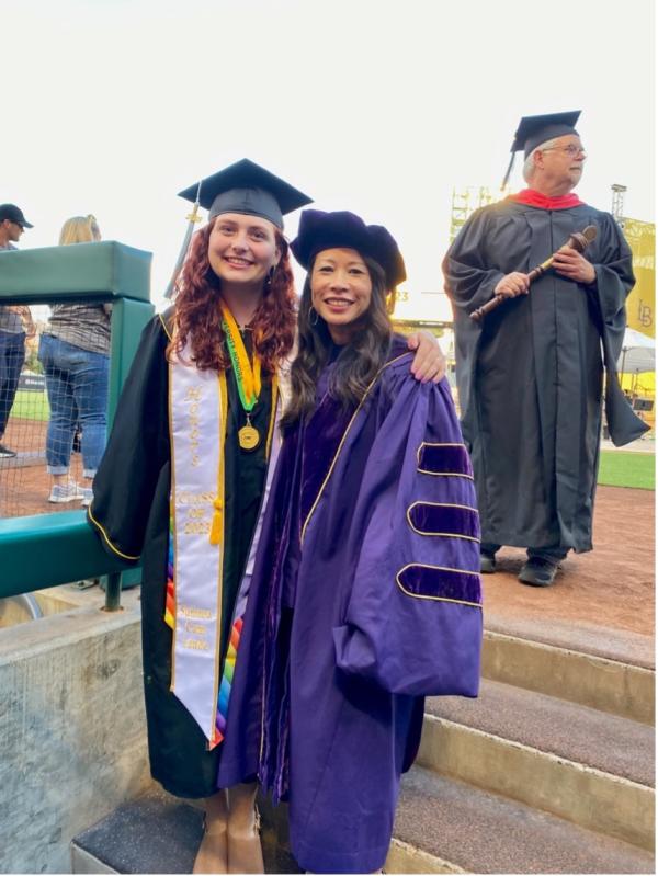 A student and faculty member pose at commencement in 2023.