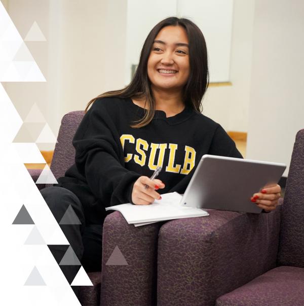 Girl smiling while looking at an iPad studying. 