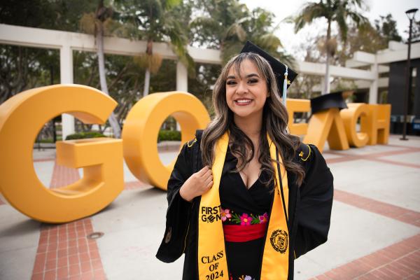 Graduate in front of Go Beach sign Graduate in front of Go Beach sign