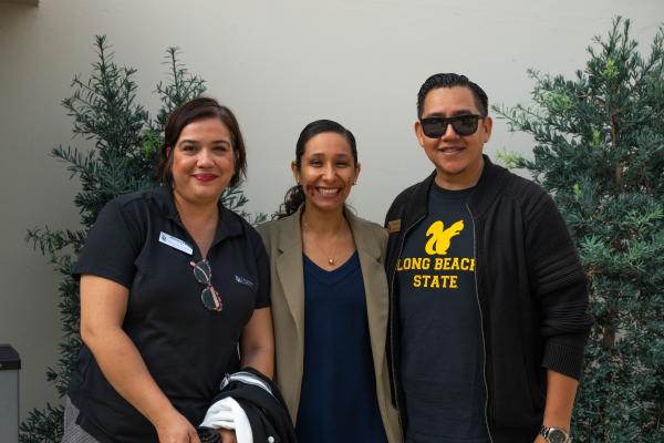 Three Latine staff members smiling together.