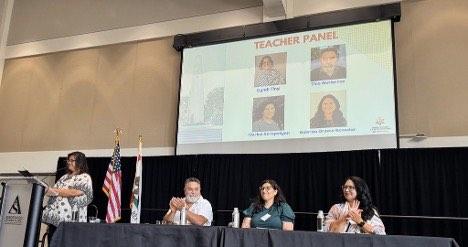 Teachers sit at a dais and answer questions during a panel discussion.