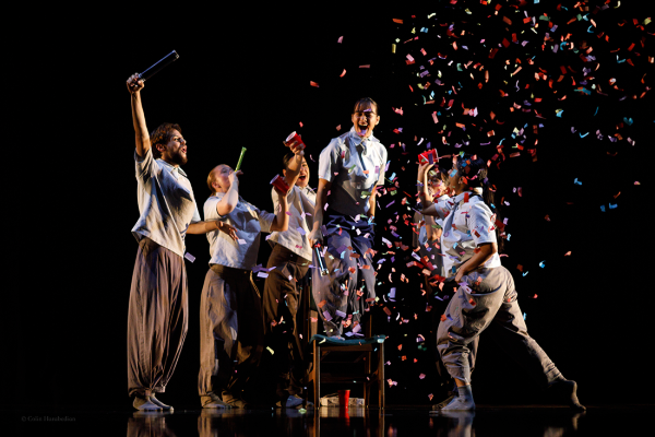 five dancers celebrate with confetti and smiles