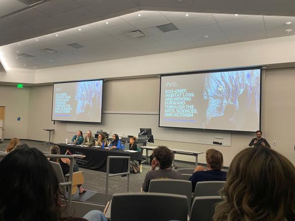 board of panels speaking in front of a screen