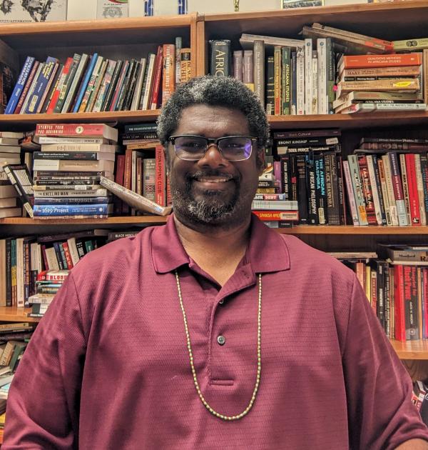 Dr. Claybrook sitting in office in front of bookshelves