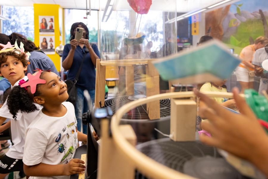Kids look to see if their handmade boats will hover in a makeshift wind tunnel at Science Learning Center