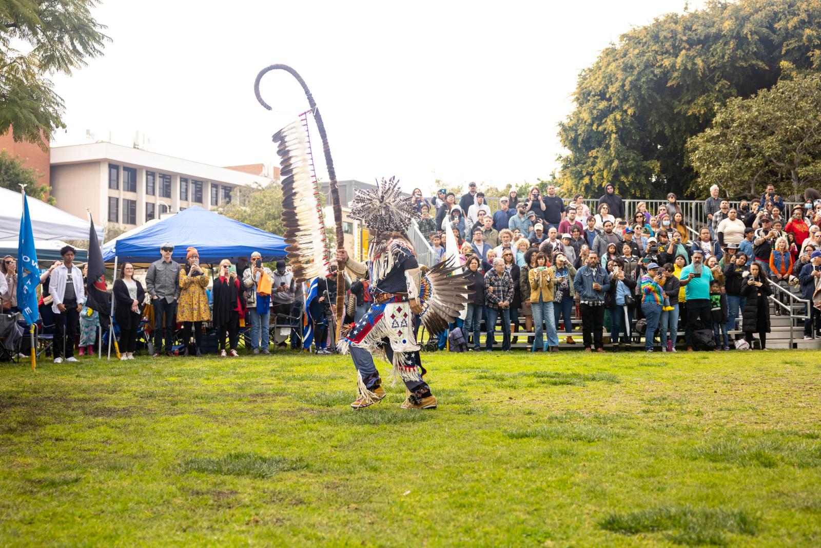 Powwow dancer in front of audience members