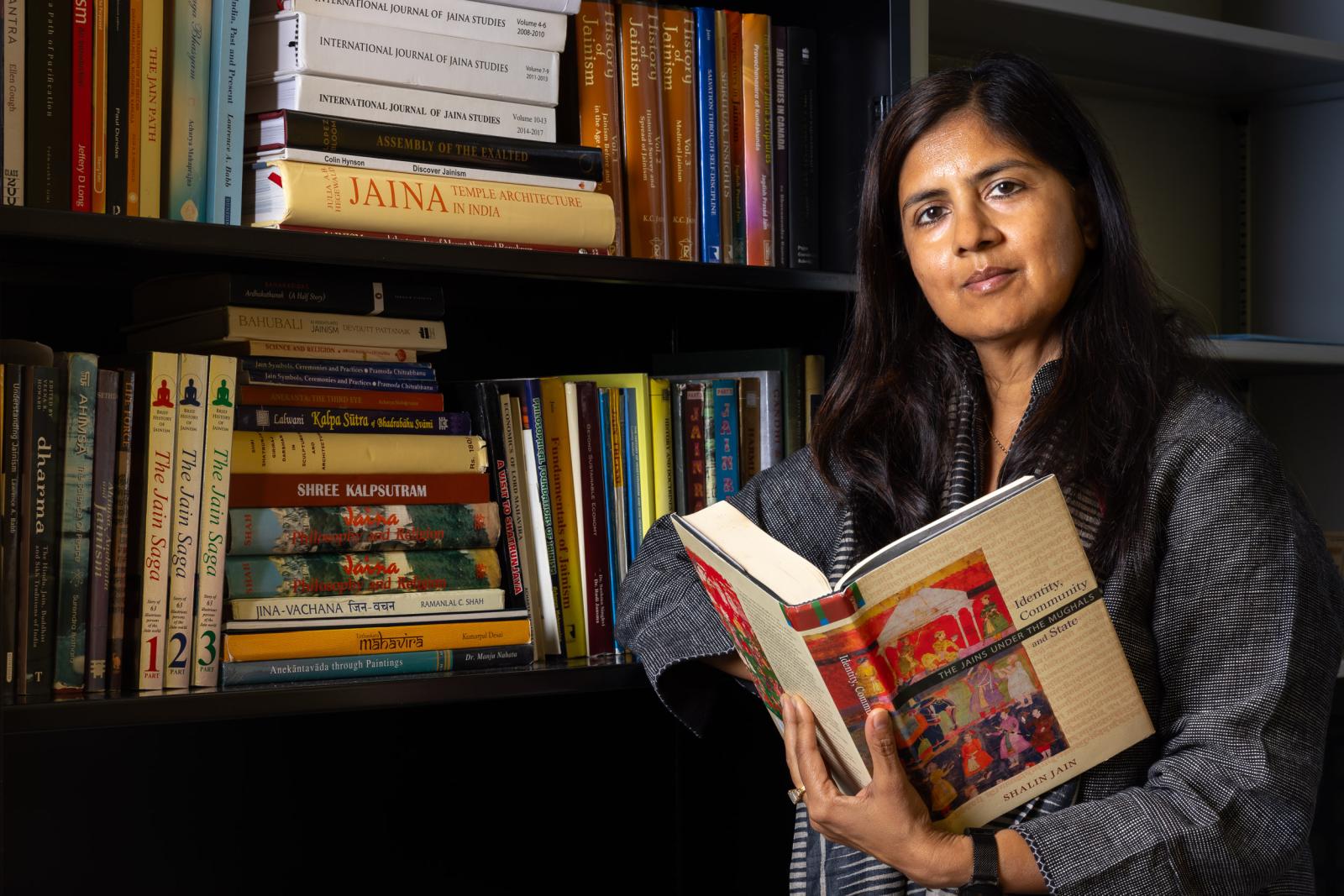 Jain Studies chair Shivani Bothra in front of her office bookshelf