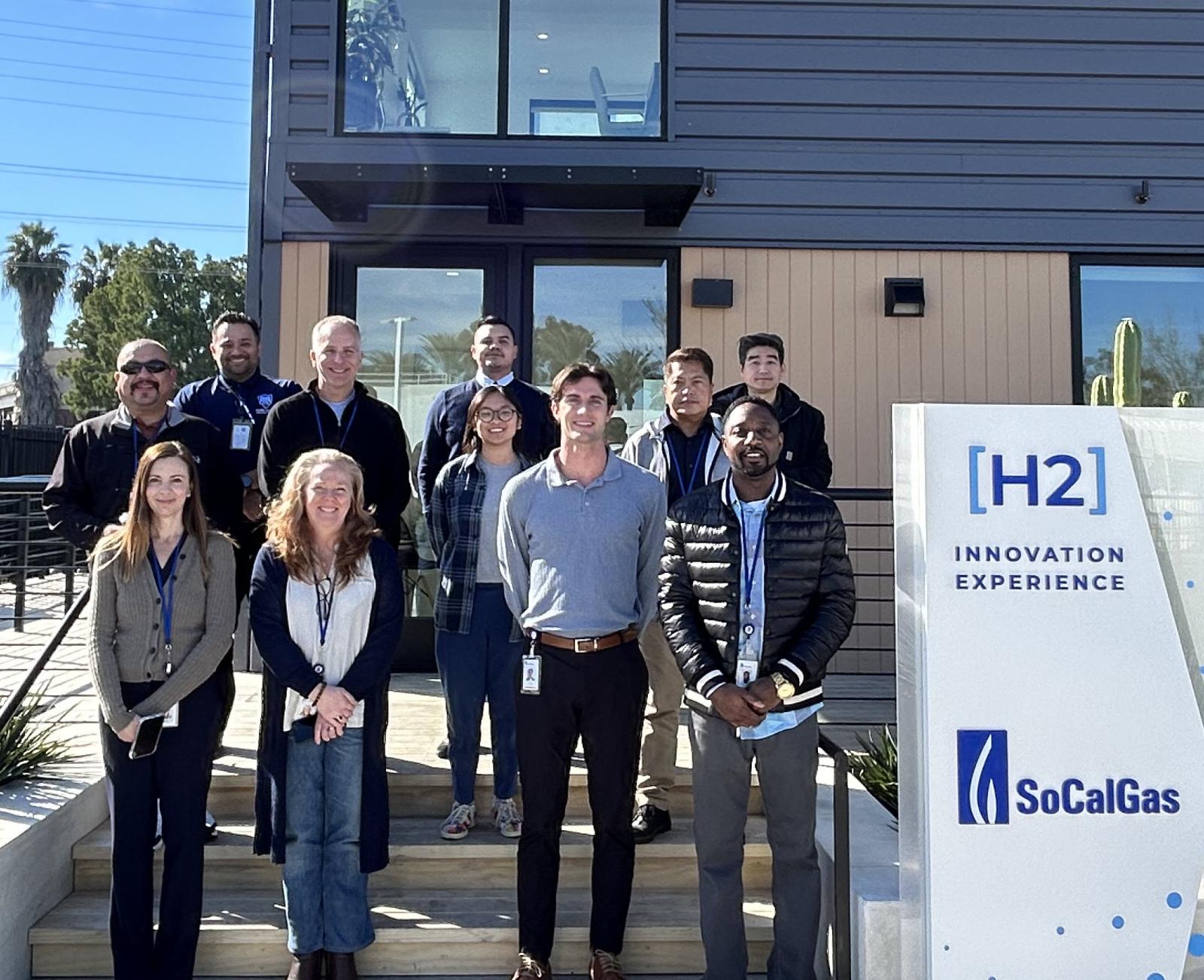 Group of adults standing in front of a newly built building