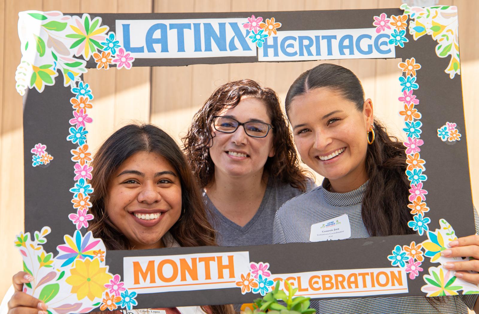 Three people smile through a "Latinx Heritage Month Celebration" frame Three people smile through a "Latinx Heritage Month Celebration" frame