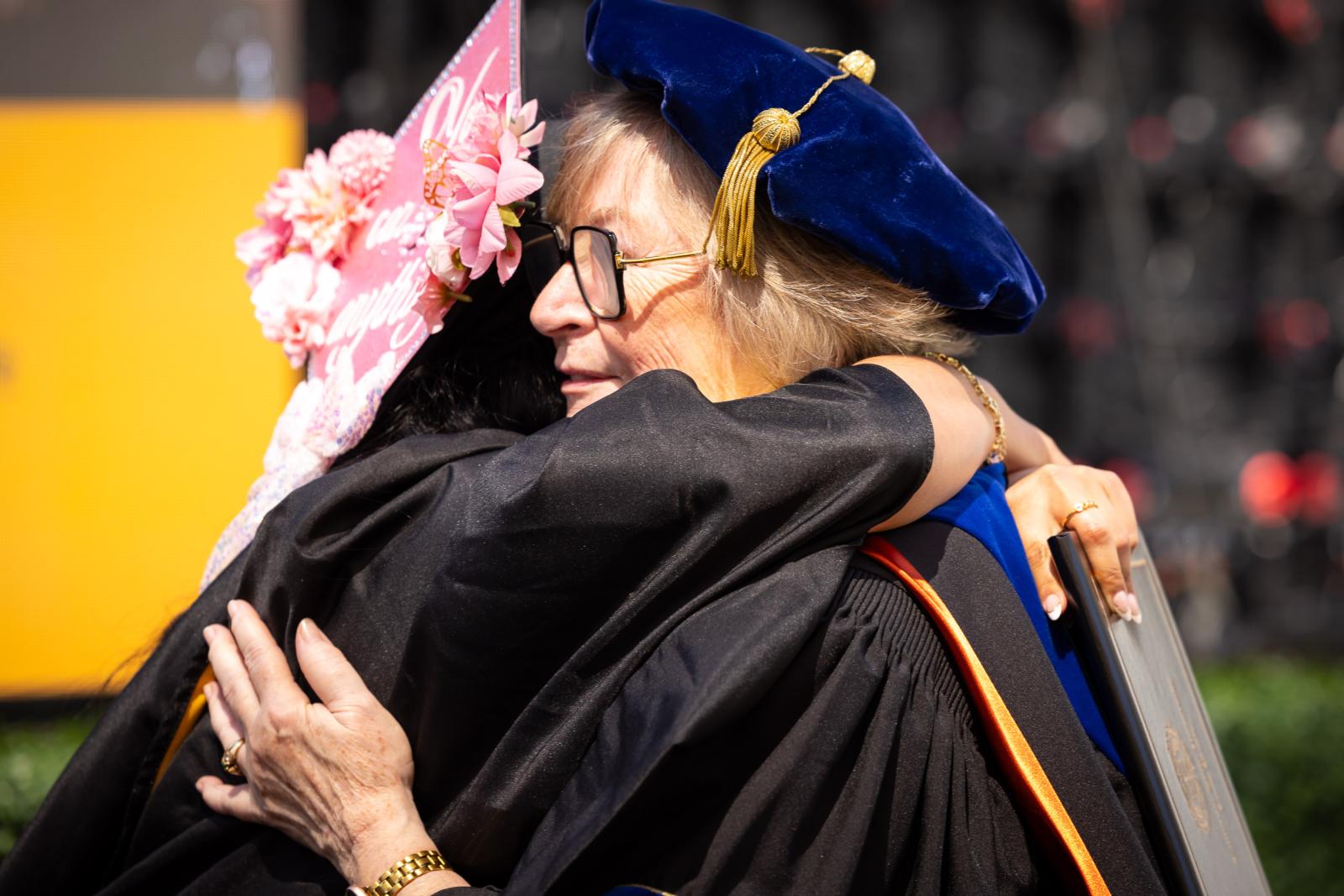 A graduate hugs President Jane Close Conoley