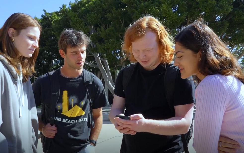 Four students checking out the BeachGO app Four students checking out the BeachGO app