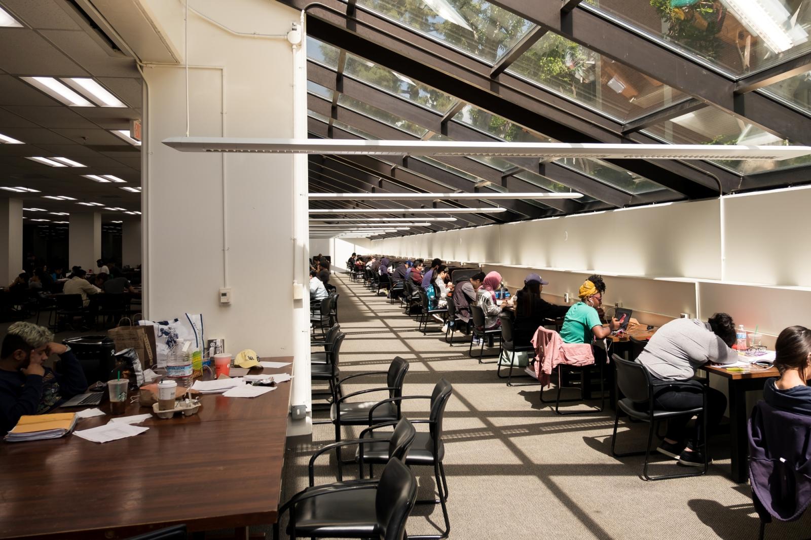 A row of students seated at library tables.
