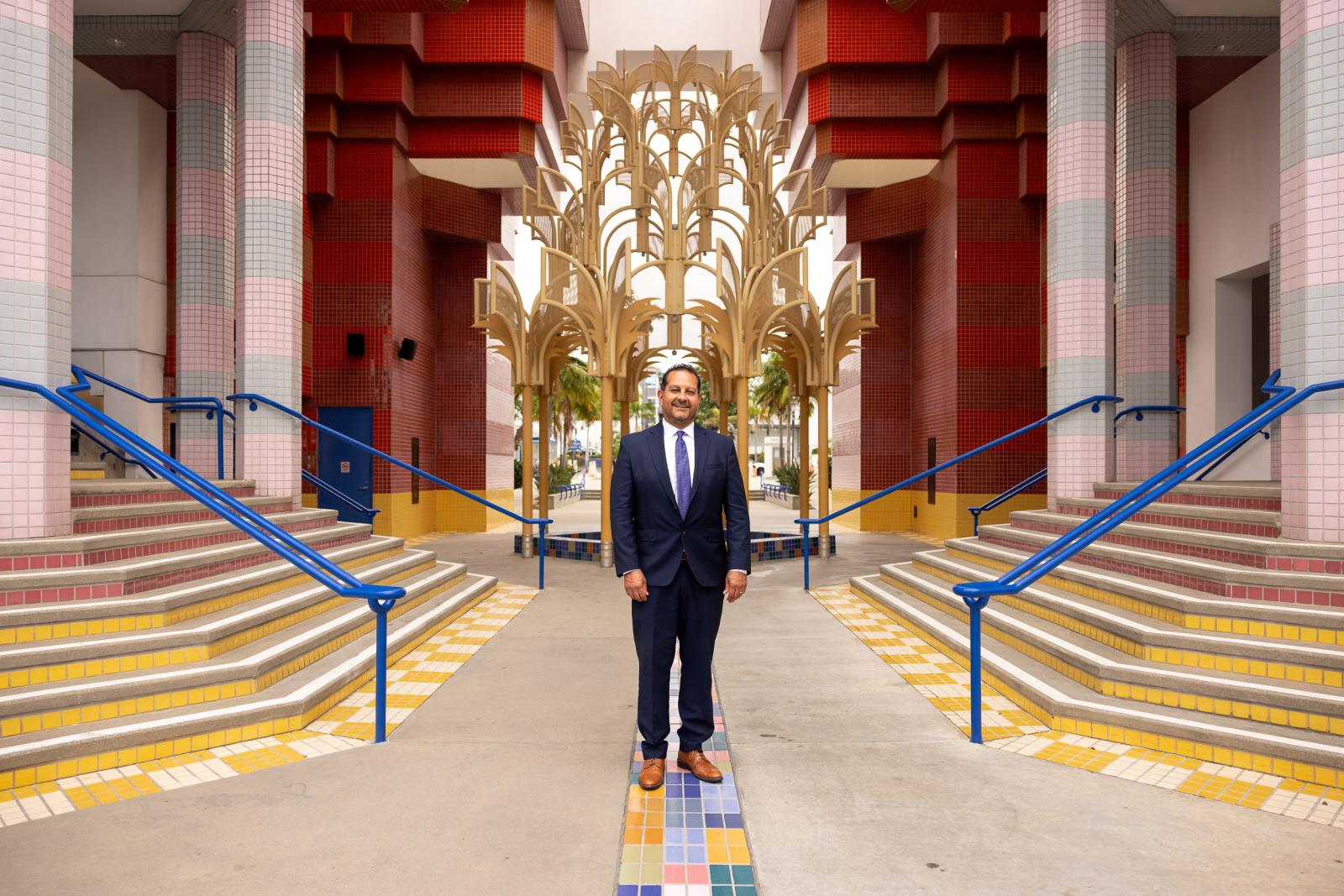 A person stands between two staircases with decoration in background