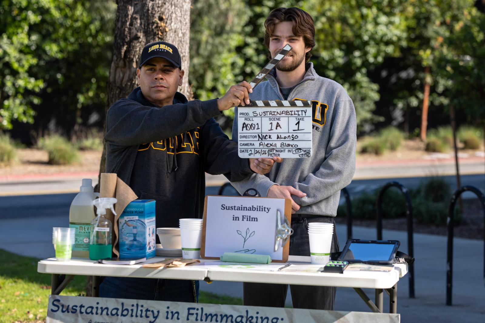 Two students at a table with "Sustainability in Film" sign