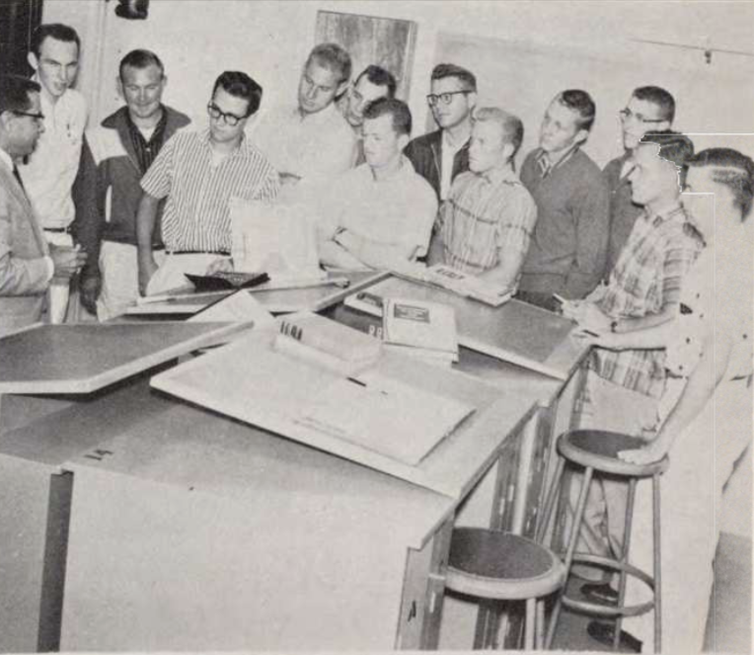 Group of students surround drafting tables in 1950s photo