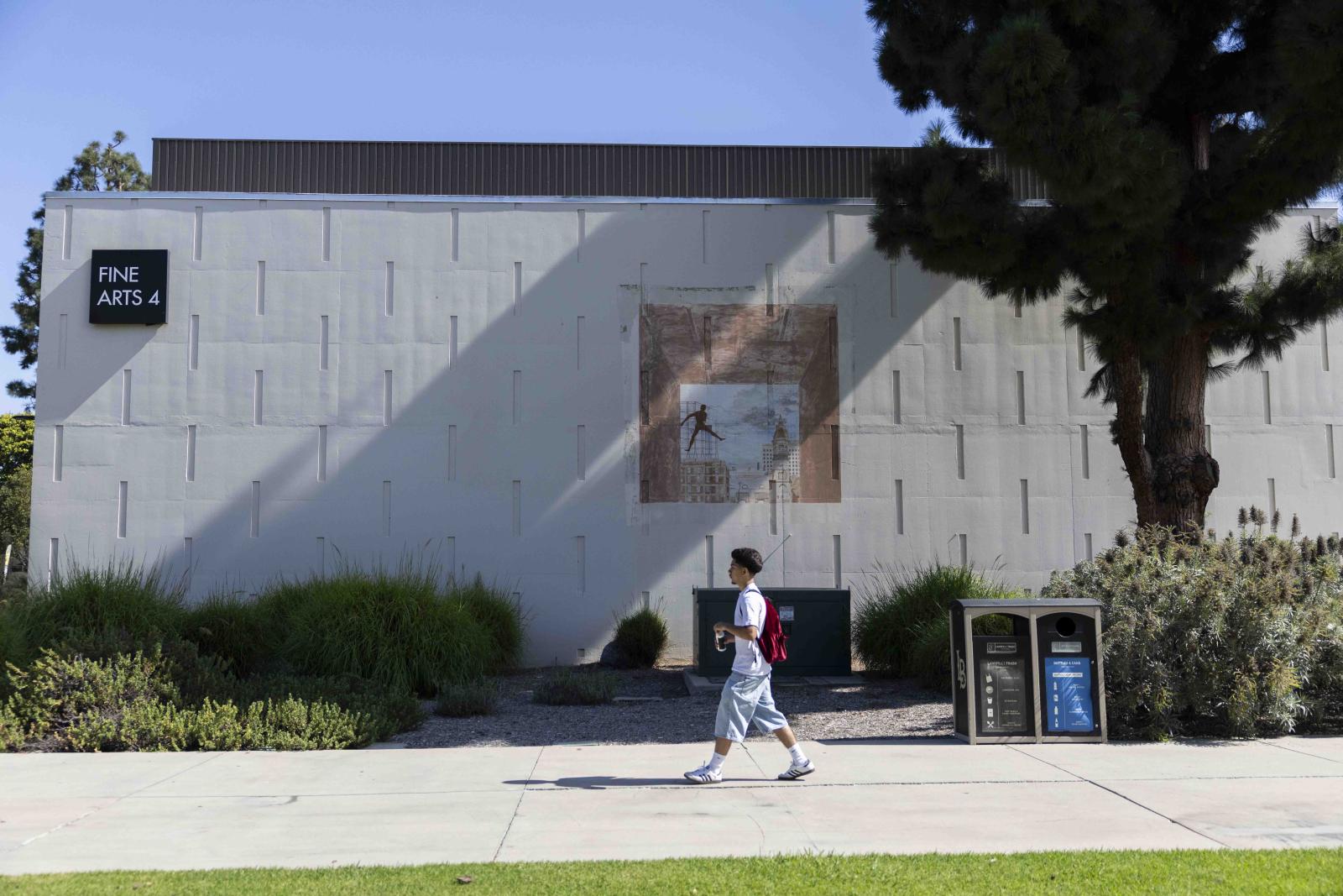 Student walking in front of Fine Arts 4 building
