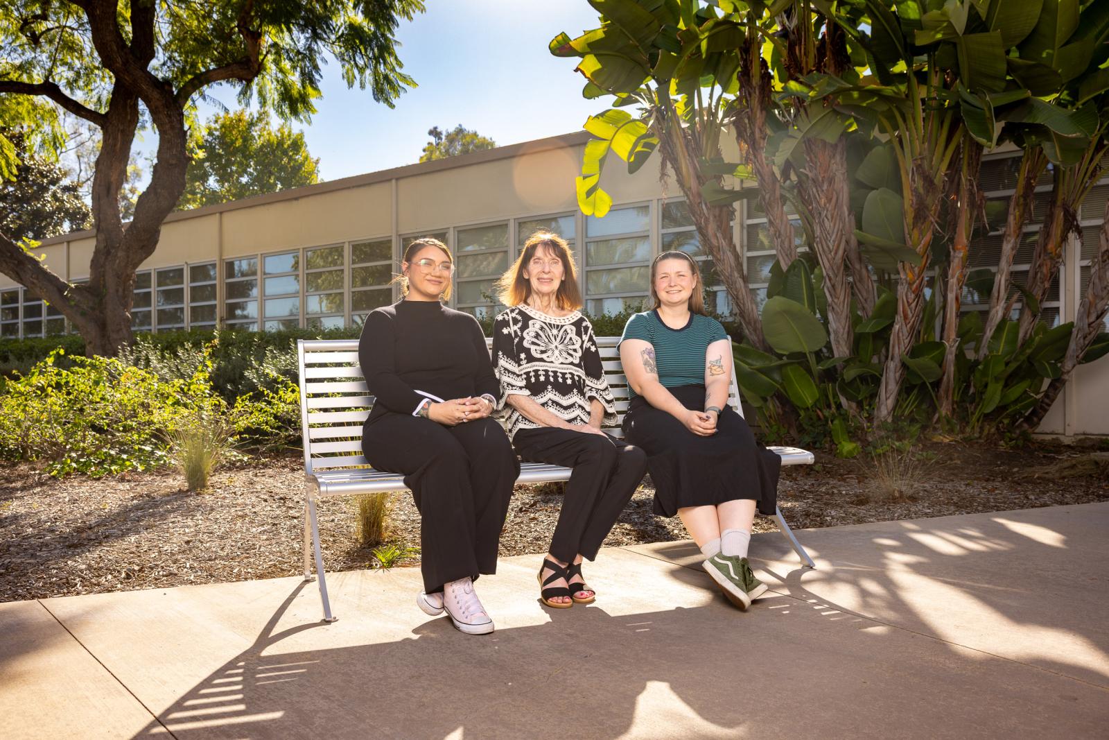 Charlotte Hamilton, Barbara Ellis and Raven Moon sitting on a bench