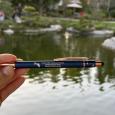 Blue pen with white EBM Japanese Garden 45th Anniversary logo, in front of the pond
