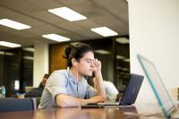 Image of student writing on a laptop