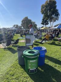 Three waste bins located on a grassy field 