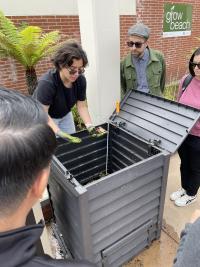 People in the Grow Beach Garden looking at a compost bin