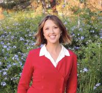Professor Schugurensky wearing a red sweater in front of flower field 