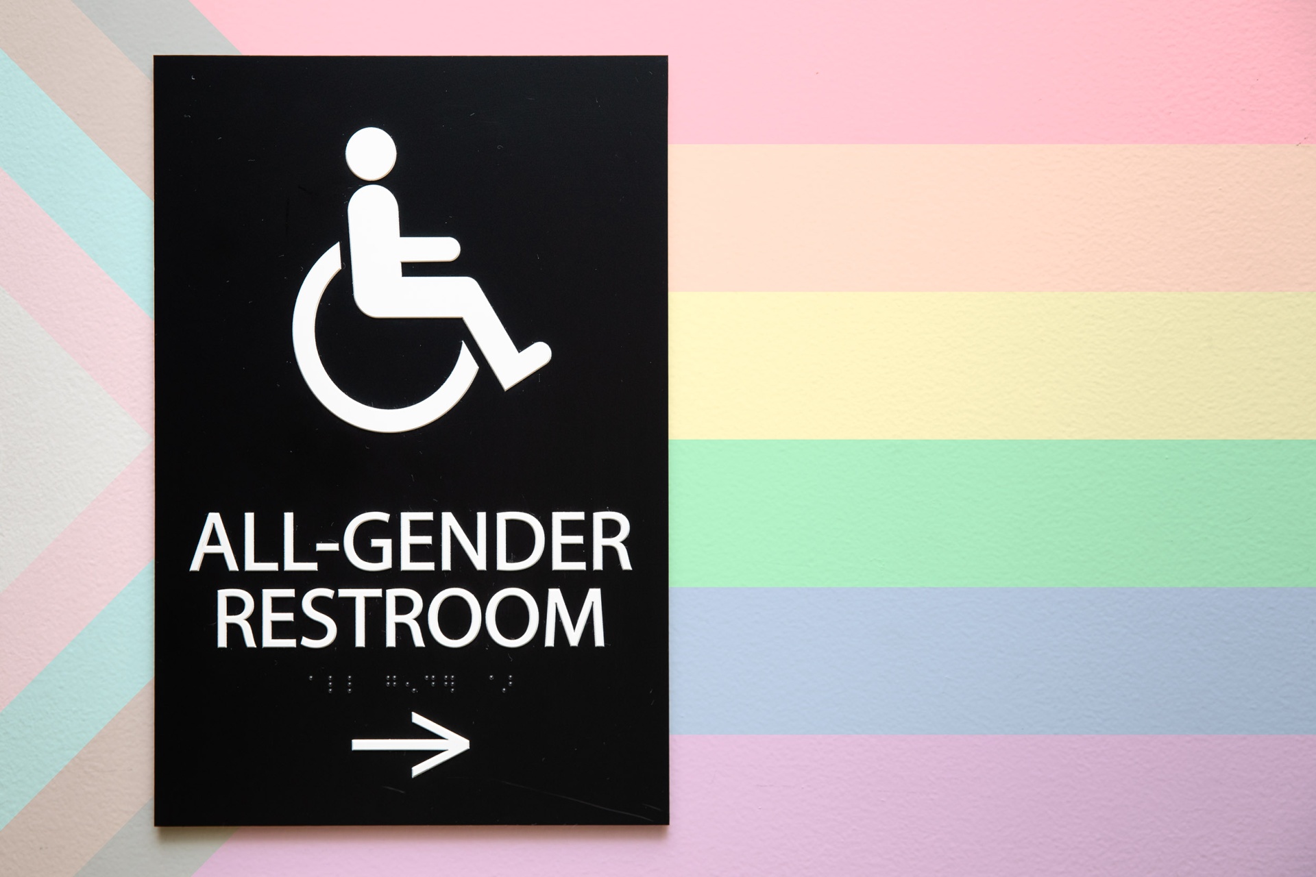 All Gender bathroom sign on rainbow background
